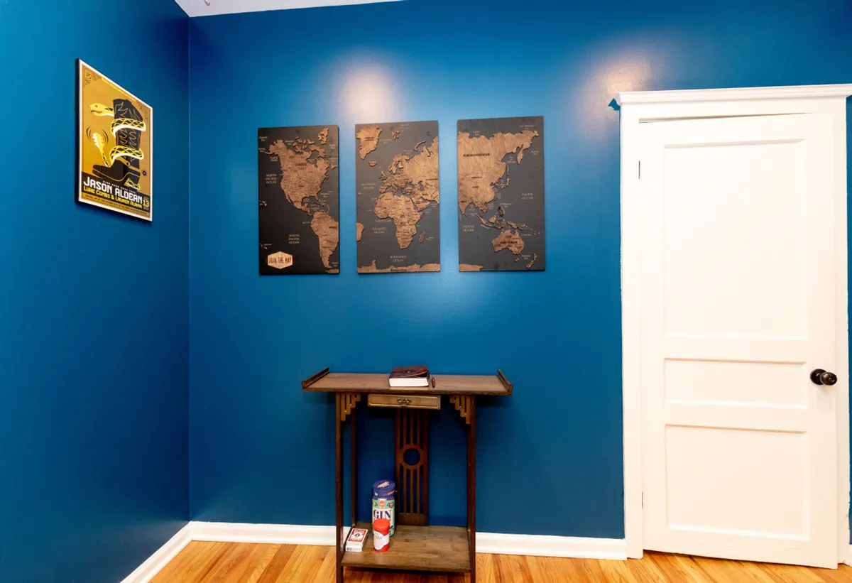 This image features a cozy yet adventurous nook with blue walls adorned by world maps, a small table, and a book, evoking a sense of curiosity and travel planning. The atmosphere is inspired and forward-looking, ideal for visitors contemplating or reminiscing about their Nashville explorations.